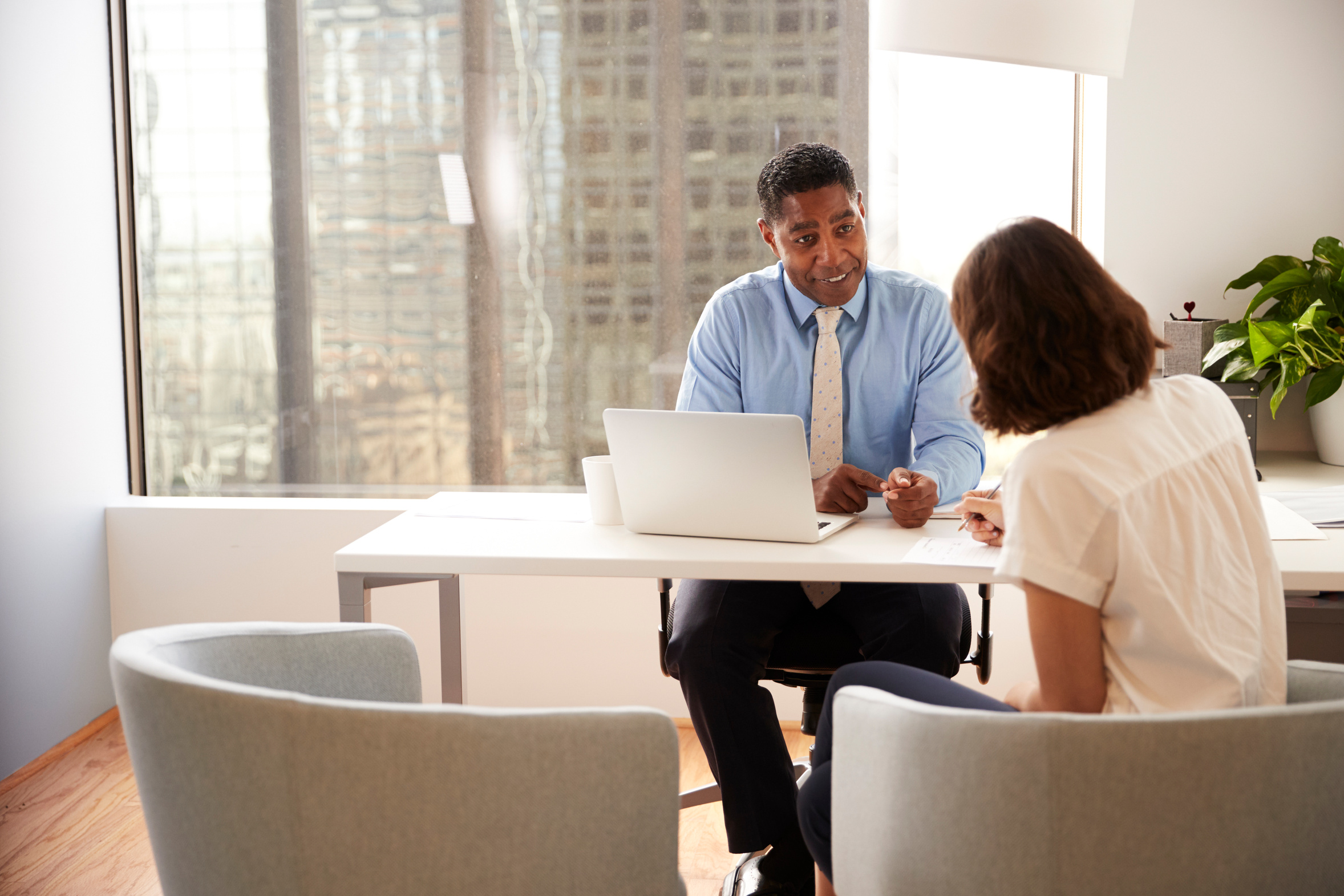 Tax advisor meeting with a client at a desk with a laptop