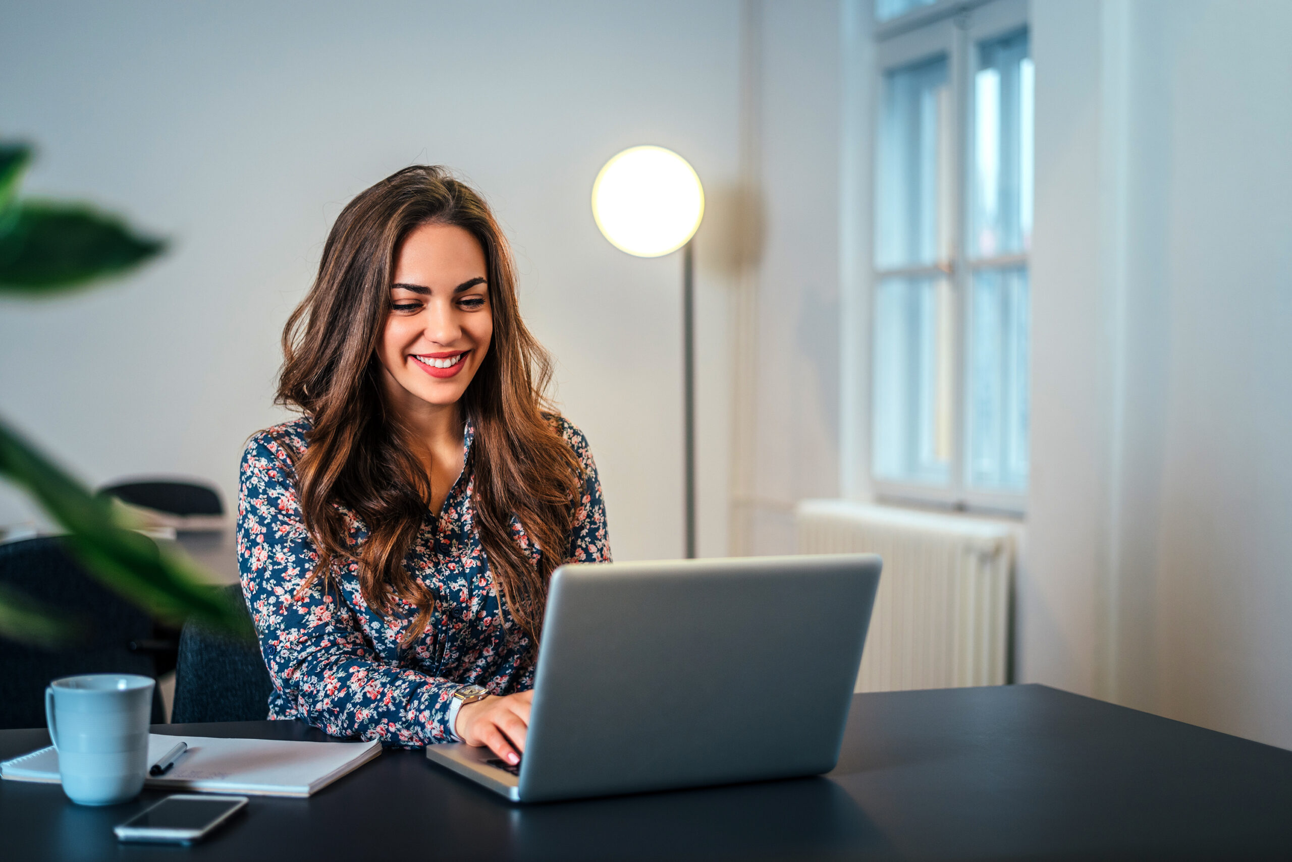 Smiling woman working on a laptop at home